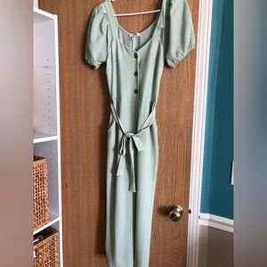 Sage romper with small, white polka dots